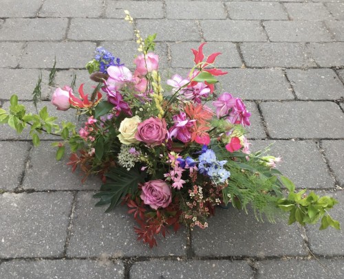 Rouwwerk 'speels' vrij model met kleurige bloemen afmeting ongeveer 60cm € 75