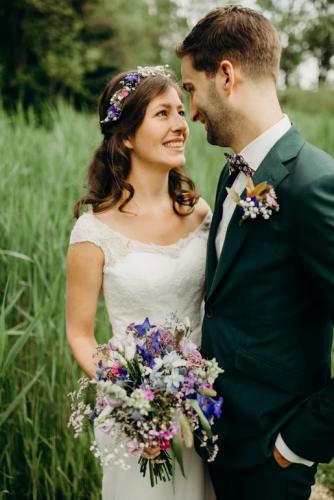 Bruidsboeket veldachtig met diverse tinten in kleine bloemetjes, bijpassende corsage en haarversiering